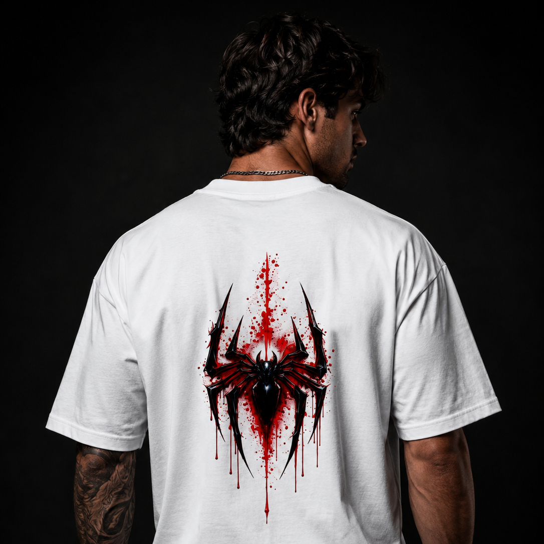 Person wearing a white t-shirt with a red and black spider design on the back against a dark background