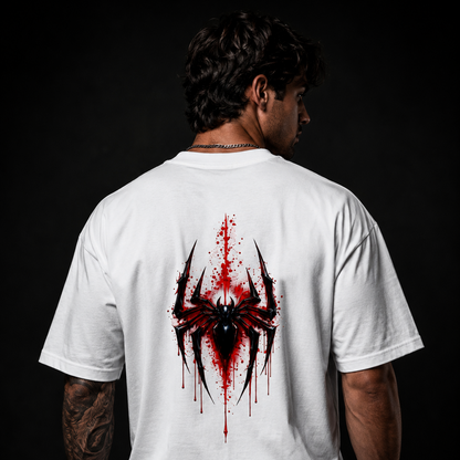 Person wearing a white t-shirt with a red and black spider design on the back against a dark background
